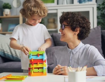 a woman sitting at a table with a child